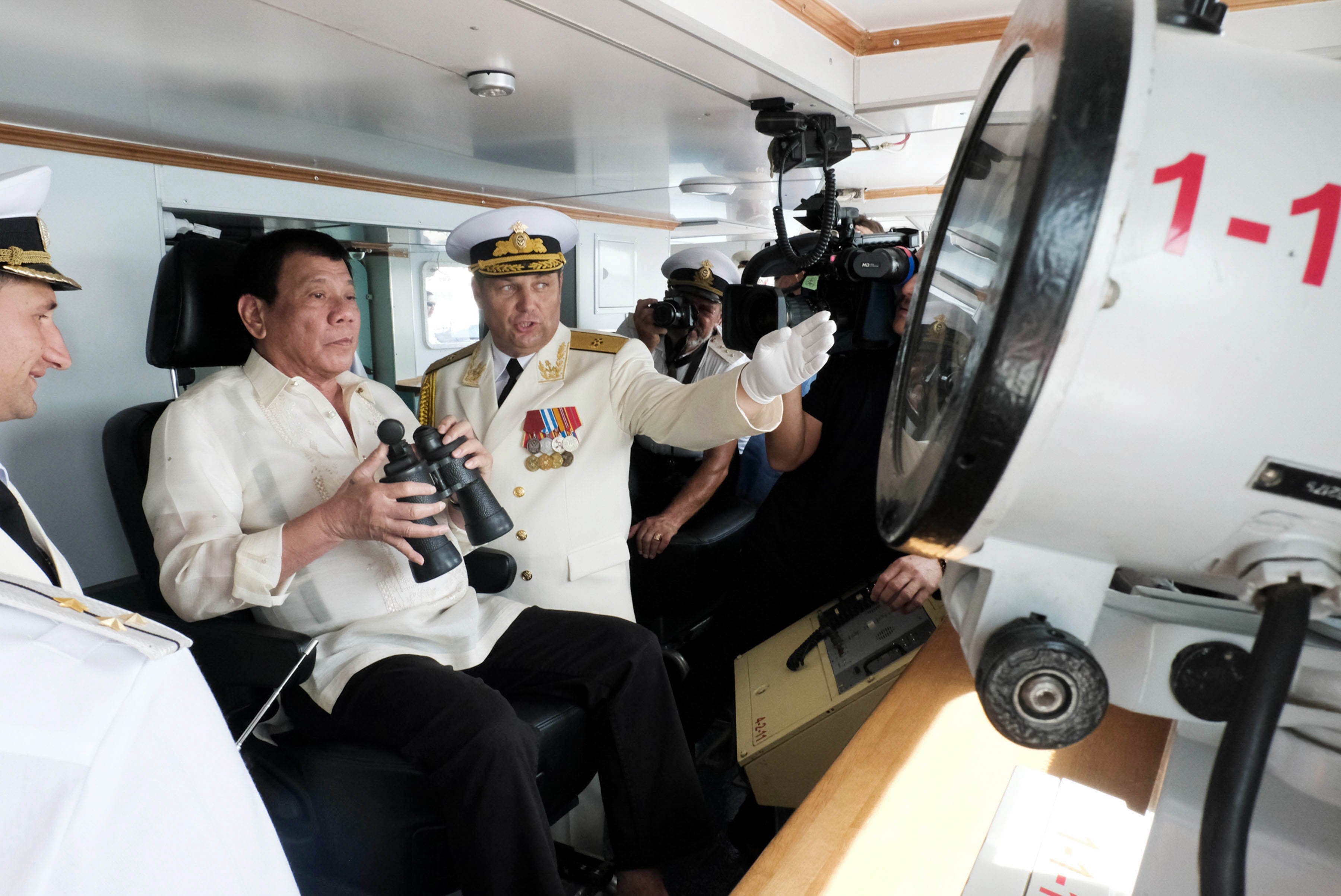 Pres. Duterte checks view from the bridge of Admiral Tributs