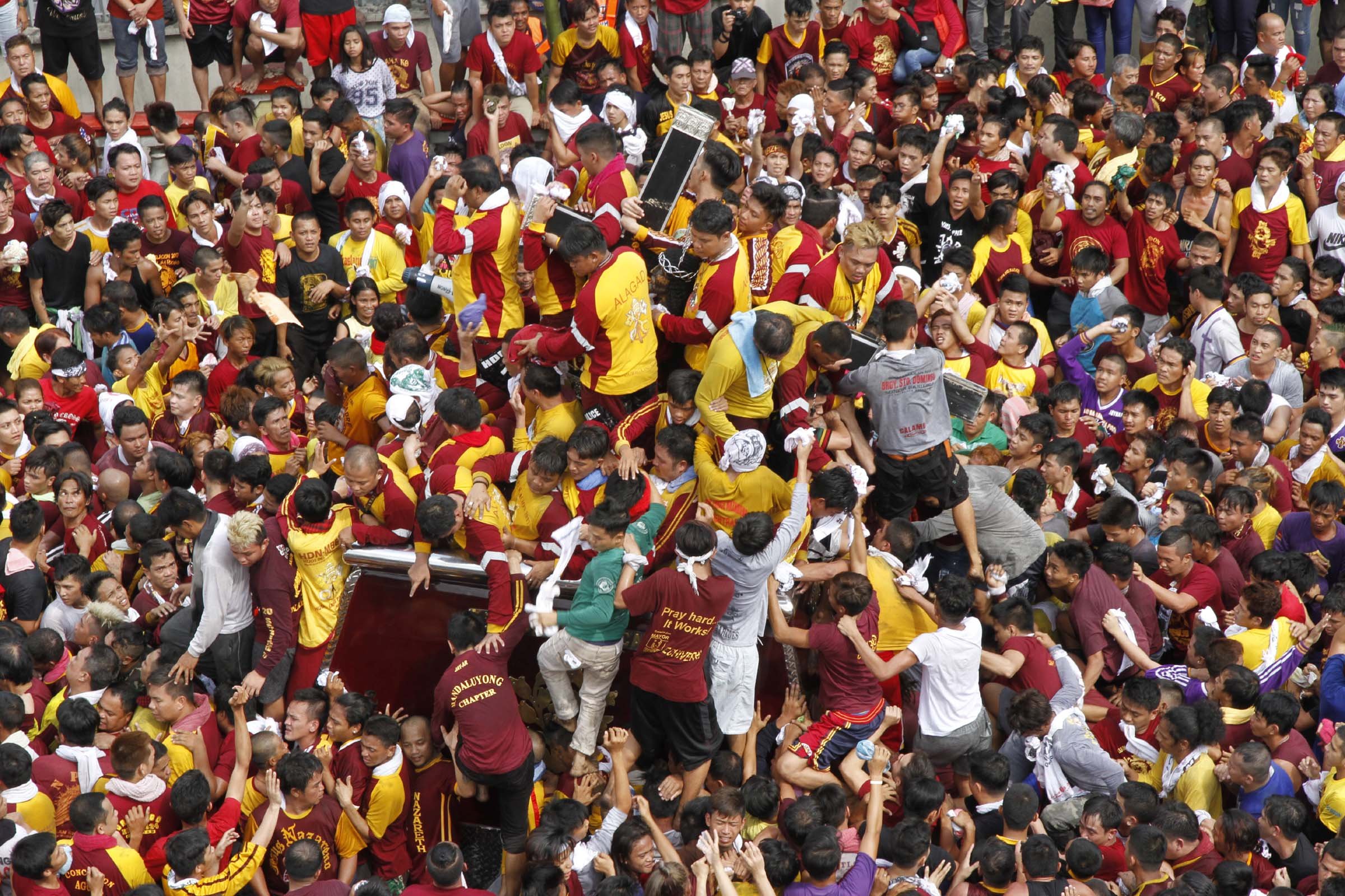 Devotees climb the carriage to touch the Black Nazarene