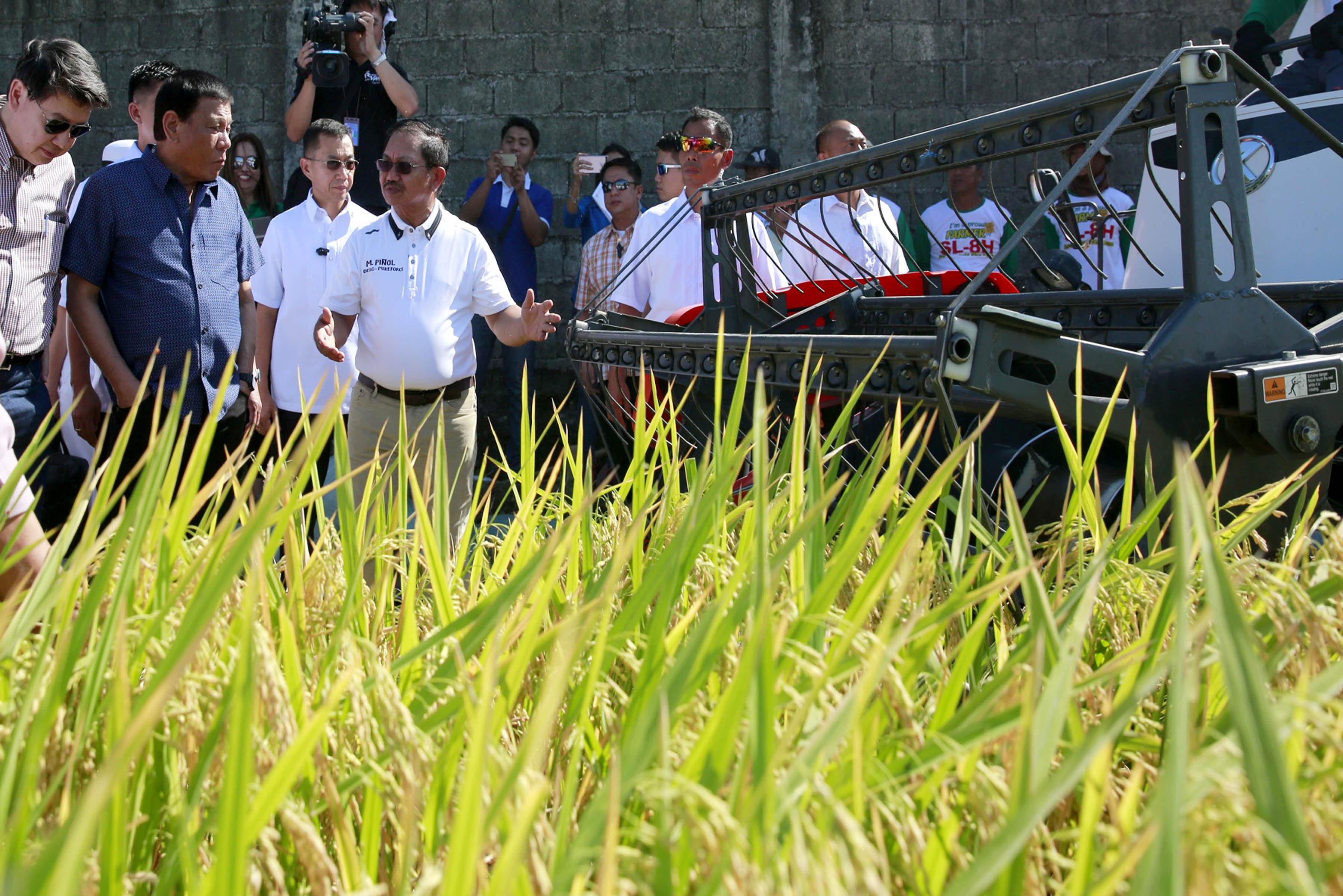 Pres. Duterte looks on as Agriculture Secretary Emmanuel Piñol shows one of the harvesting equipment