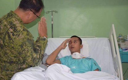 <p>Lt. Gen. Carlito Galvez Jr., Westmincom chief, during a visit on Thursday, responds to the salute of Marine PFC Vladimir Ramos, who was wounded in a clash with the Abu Sayyaf bandits last February 11 in Panamao, Sulu. Ramos survives for 16 days at the hospital’s Intensive Care Unit. <em><strong>(Photo courtesy: Westmincom PIO)</strong></em></p>