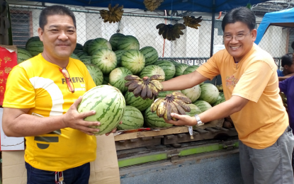 <p>Agustin Garcia (left), a participant of DA’s “Tienda-Tienda” trade exposition, on Friday shows to customers the watermelon he grows in an east coast village of Zamboanga City. <em><strong>(Photo by: Teofilo P. Garcia Jr.)</strong></em></p>